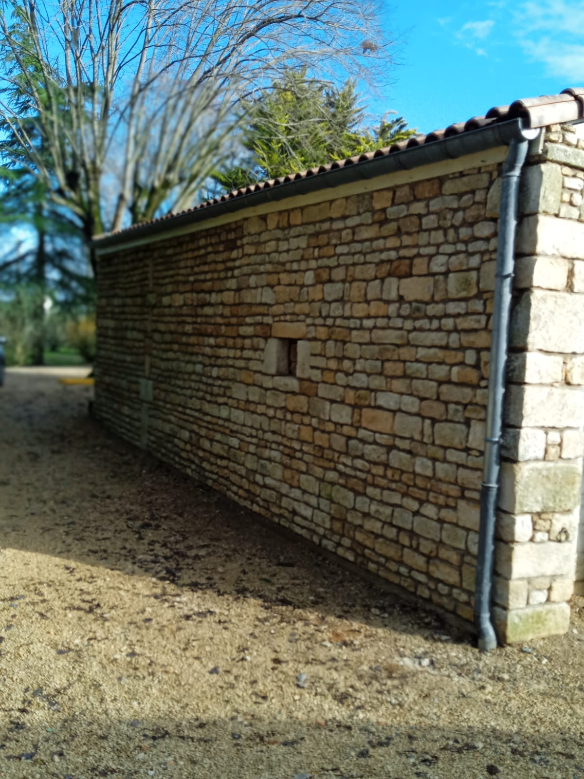 Mur en pierre calcaire restauré à Vouillé, Deux-Sèvres
